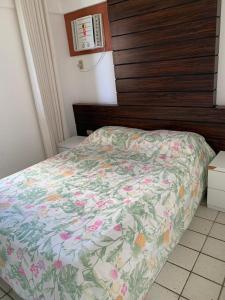 1 dormitorio con 1 cama con edredón de flores en Flat em Recife a beira-mar de Boa Viagem, en Recife