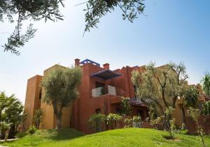 an exterior view of a house with trees at Vizir Center Appart 301 in Marrakesh