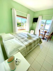 a bedroom with a large bed and a table and chairs at Hotel Enseada in São Francisco do Sul