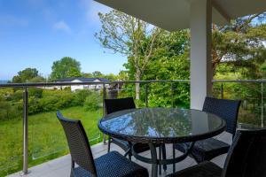 a patio with a glass table and chairs on a balcony at Apartament Helios in Jastrzębia Góra