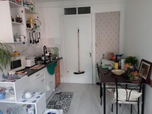 Castelnau-DurbanTiny Studio Ariège Pyrénées的一间带桌子和白色门的小厨房