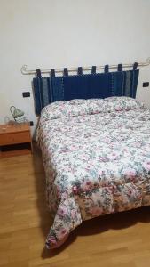 uma cama com um edredão floral num quarto em B&B DA SILVESTRO em Tempio Pausania