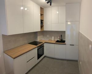 een witte keuken met witte kasten en een wastafel bij Apartman SARA in Trebinje