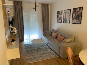 een woonkamer met een bank en een tafel bij Apartman SARA in Trebinje