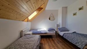 a bedroom with two beds and a wooden ceiling at Przystań wodnica in Ustka +96 photos