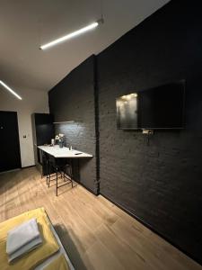 Habitación con mesa y TV en la pared. en DarkHouse FONDOVALLE, en Łódź