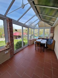 a conservatory with a table and chairs in a room with windows at Przystań wodnica in Ustka