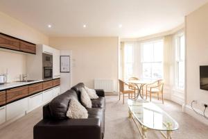 a living room with a black couch and a table at CASTLEBANK HOUSE FLATS, DINGWALL in Dingwall