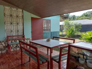 eine Terrasse mit einem Tisch und Stühlen auf einer Terrasse in der Unterkunft Lodging Adventure La Gamba in Gamba