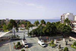 two white vehicles parked in a parking lot near the ocean at Royal Homes 402 in Antalya