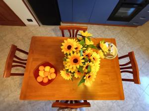 una mesa de madera con girasoles y naranjas. en TERRAZZA GRANDE, en Librizzi