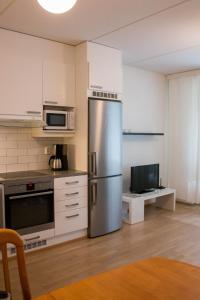 La cuisine est équipée d'un réfrigérateur en acier inoxydable et d'un four micro-ondes. dans l'établissement Lahti Center House, à Lahti