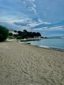 a sandy beach with the ocean in the background at Apartmani Branko Vojnovic in Omiš