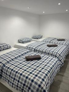a group of three beds in a room at Downtown Apartments in Alicante