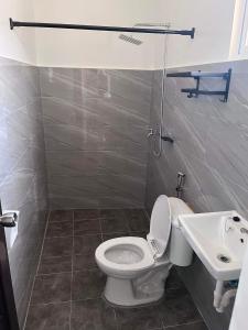 a bathroom with a toilet and a sink at Sidra Ville Apartment in Balanga