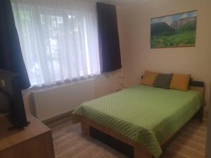 a small bedroom with a bed and a window at Zoldrebi apartment in Turda