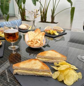 einen Tisch mit Sandwiches und Chips und ein Glas Bier in der Unterkunft La Boutique Puerta Osario in Córdoba