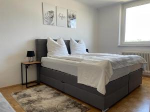 1 dormitorio con 1 cama grande con almohadas blancas en TAMLiving Zentrum Luxus Parken Messe WIFI Traumaussicht Sunrise&Sunset en Graz