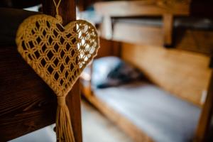 a wooden heart is hanging on a bed at Domki na Górniej Łące - Dwa Wróble in Łazany