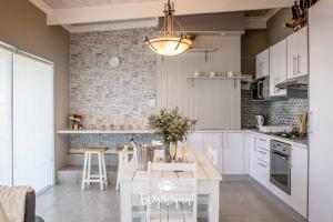a kitchen with white cabinets and a table with chairs at * 281 Golden Mile Boulevard in St. Helena Bay