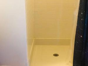 ducha con bañera amarilla y drenaje en King Size Studio in Heart of Downtown, en Columbus