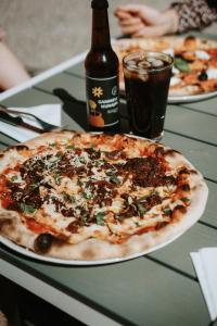 a pizza sitting on a table with a bottle of beer at Gammelgård Pizza & Padel Resort in Nauvo