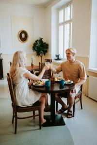 a man and woman sitting at a table eating food at Gammelgård Pizza & Padel Resort in Nauvo