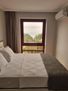 a bedroom with a large bed with a window at Royal Homes 403 in Antalya