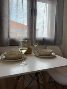 a white table with two glasses of white wine at Up To The Sea in Agios Ioannis Kaspaka