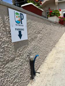 a hose hooked up to a wall with a sign at Up To The Sea in Agios Ioannis Kaspaka