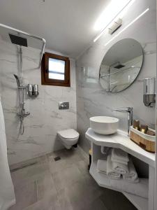 a bathroom with a sink and a toilet and a mirror at Up To The Sea in Agios Ioannis Kaspaka