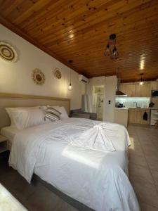 a large white bed in a room with a kitchen at Up To The Sea in Agios Ioannis Kaspaka