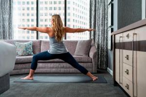 a woman doing yoga on a rug in front of a couch at The Ritz-Carlton Atlanta in Atlanta