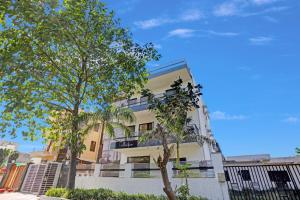 a white building with trees in front of it at Collection O Naveen Stay in Gurgaon