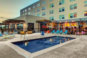 un hotel con piscina frente a un edificio en Aloft Wichita, en Wichita