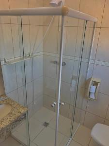 a shower with a glass door in a bathroom at Hotel Enseada in São Francisco do Sul