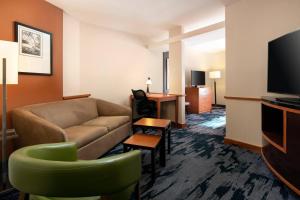 a living room with a couch and a flat screen tv at Fairfield Inn & Suites Redding in Redding