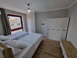 1 dormitorio con 2 camas y ventana en Royal Homes 404, en Antalya