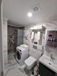 a bathroom with a toilet and a washing machine in it at Royal Homes 404 in Antalya