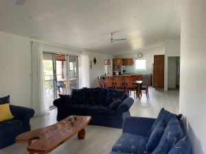 a living room with blue couches and a table at 1 Tree Escape in Wooli