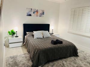 una camera da letto con un letto con un paio di scarpe sopra di Luxurious Designer Miami Retreat 3 Bedroom House a Miami