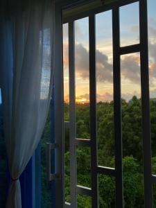 a window with a view of the sunset at Tiny Apartment By Merengue House in Santo Domingo
