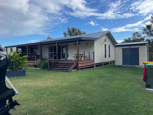a mobile home with a porch and a lawn at 1 Tree Escape in Wooli