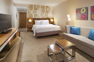 a large hotel room with a bed and a couch at Courtyard by Marriott Sunnyvale Mountain View in Sunnyvale