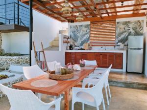 Las Terrazas de Barili في Barili: مطبخ مع طاولة خشبية وكراسي بيضاء
