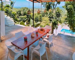 a wooden table and chairs on a patio at Las Terrazas de Barili Private Resort in Barili