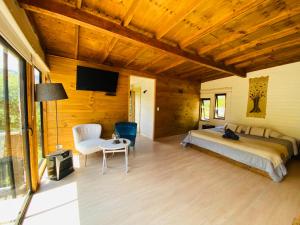 a bedroom with a bed and a table and a tv at Cabaña Auquinco Lago Ranco in Ranco