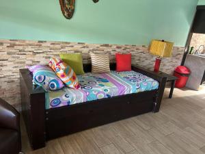 a bed with colorful pillows on it in a room at Villas Paraíso Jacó B20 in Jacó