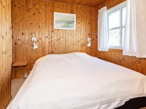 a bedroom with a bed in a wooden wall at Family-friendly Retreat near Beach - By Traum Ferienwohnungen in Lild Strand