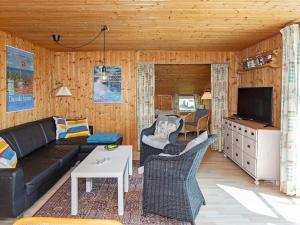 uma sala de estar com um sofá e uma televisão em Three-Bedroom Holiday home in Frøstrup 1 em Lild Strand